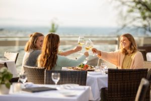Freundinnen stoßen mit Wein an auf der Sonnenterrasse des Hofgut Laubenheimer Höhe